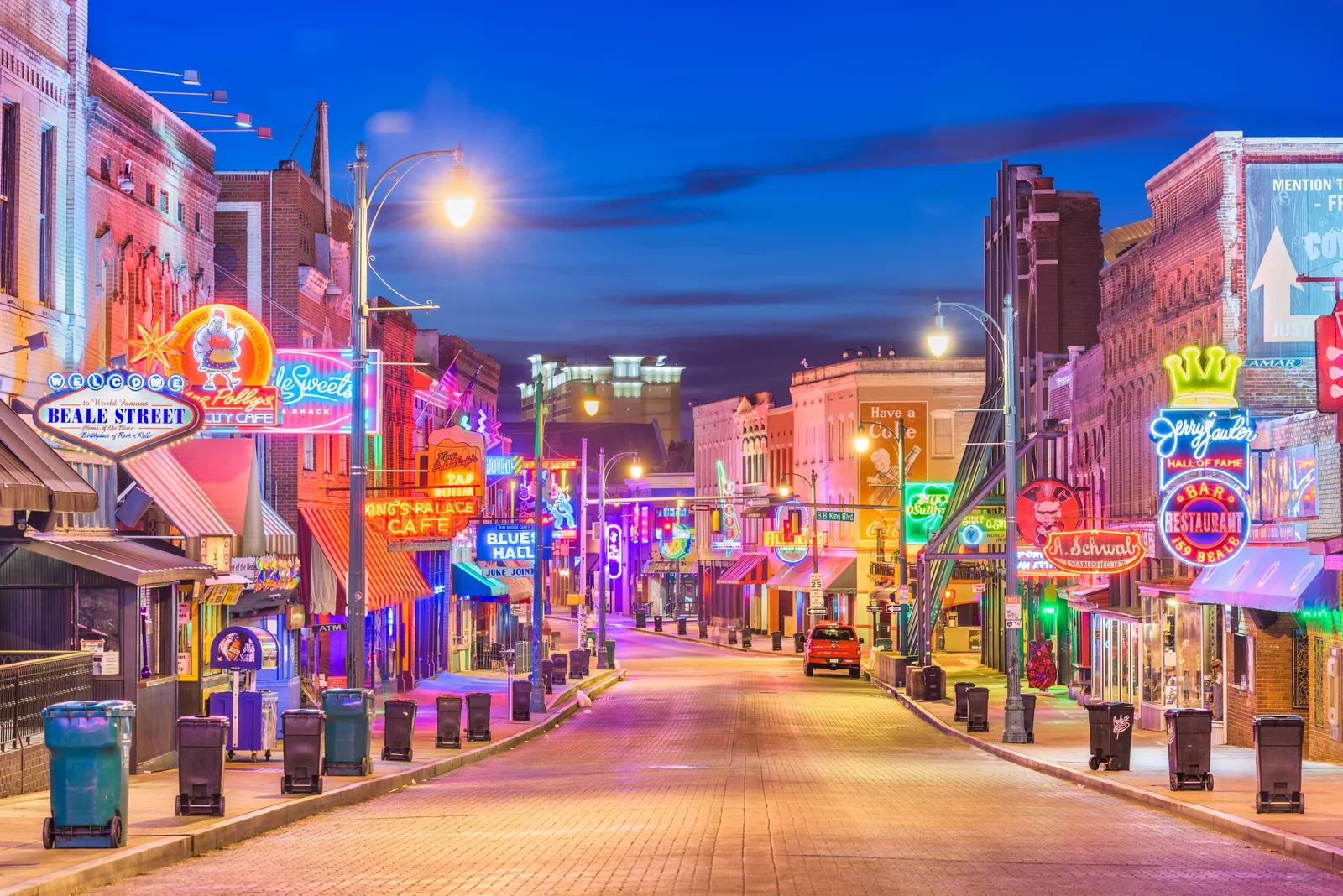 A dusk view of historic Beale Street in Memphis, featuring vibrant neon signs that highlight the city's commercial dependence on reliable electric utility infrastructure.